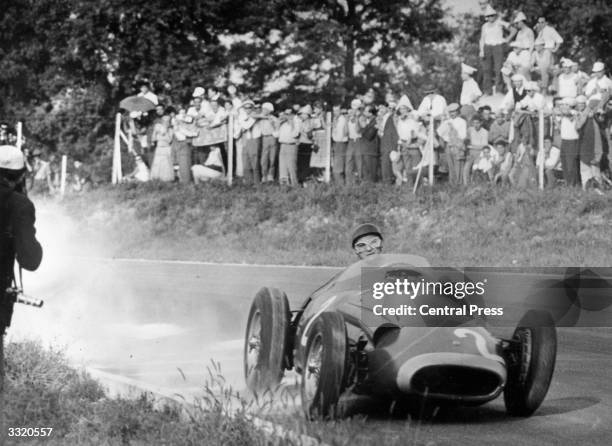 World champion Argentinian racing driver Juan Manuel Fangio in action driving a Maserati at the 1957 Italian Grand Prix at Monza. He finished second...