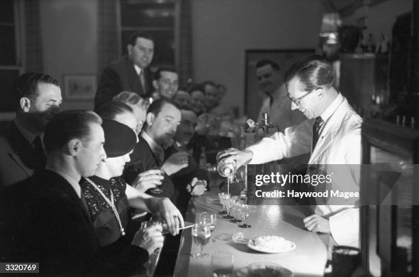 Barman pouring one of his special cocktails into four glasses during a Gastronomic Festival at the Grand Hotel in Torquay. Original Publication:...
