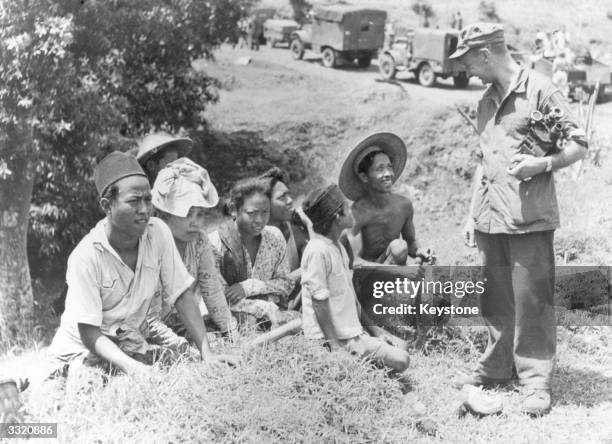 Dutch Army Film Unit Cameraman stops to talk to Indonesians during advances against Republican forces.