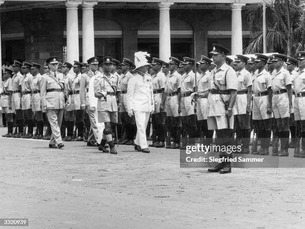 The governor of Mauritius, Sir Colville Montgomery Deverell, inspects a detachment of the new Mauritius Volunteer Force, which has replaced the...