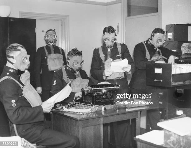 Policemen at Oxford Central Police Station, where the police chief has ordered his men to wear their gas-masks, wherever they are, for ten minutes in...