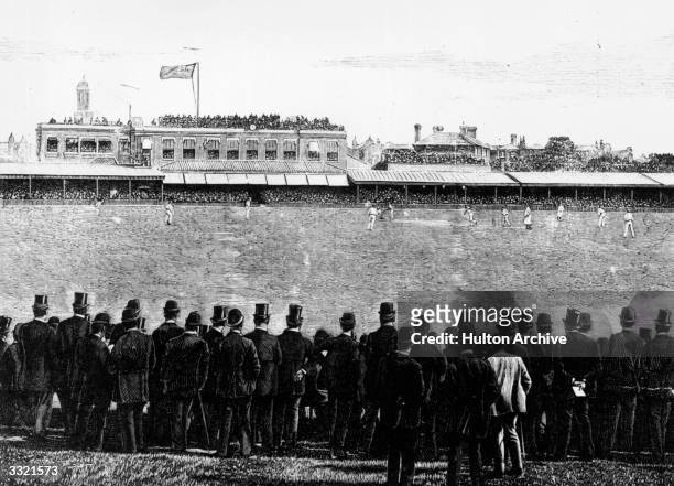 Gentlemen watching W G Grace bowling during a cricket match at the Oval, London.