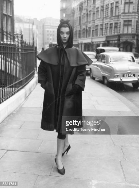 Fashion model wearing a dress and coat by Balenciaga during rehearsals for an appearance on the television show 'Fashions From Paris'.