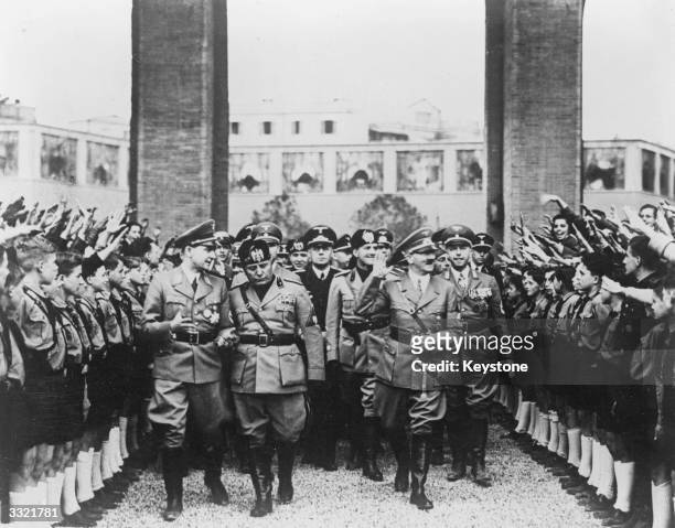 German dictator Adolf Hitler and Italian prime minister Benito Mussolini arrive at Massenzio Hall, Rome. They are welcomed and saluted by supporters,...