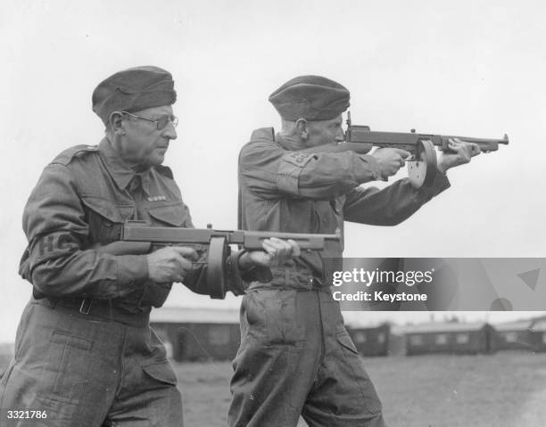 Two members of the Home Guard, armed with American Thompson sub-machine or 'Tommy' guns, during training at a rifle range in Western Command, circa...