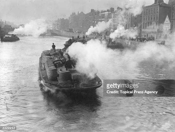 Steam-powered barges carrying barrels of stout in Dublin.