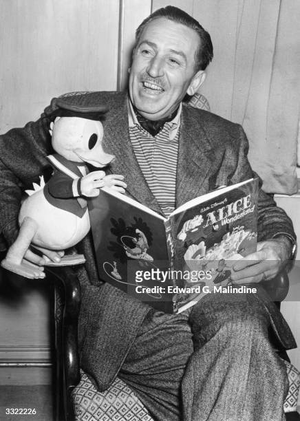 Creator of Mickey Mouse Walt Disney arrives in London to see the premiere of his latest film. He holds a model of his character Donald Duck whilst...