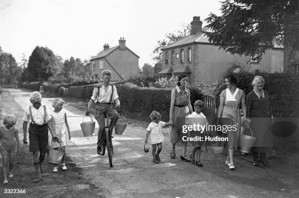 Villagers from Holmer Green, near High Wycombe, Buckinghamshire, carrying buckets in search of water. The area is experiencing a drought following a...