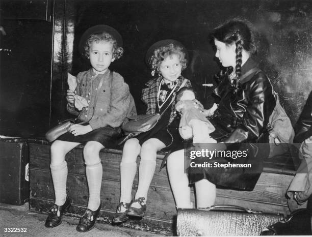 Three Jewish refugee children from Nazi Germany, waiting to be collected by their relatives or sponsors at Liverpool Street Station, London, after...