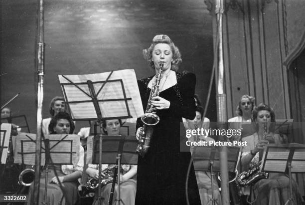 British alto saxophonist and band leader Ivy Benson, soloing on stage, backed by her band the Ladies Dance Orchestra. Original Publication: Picture...