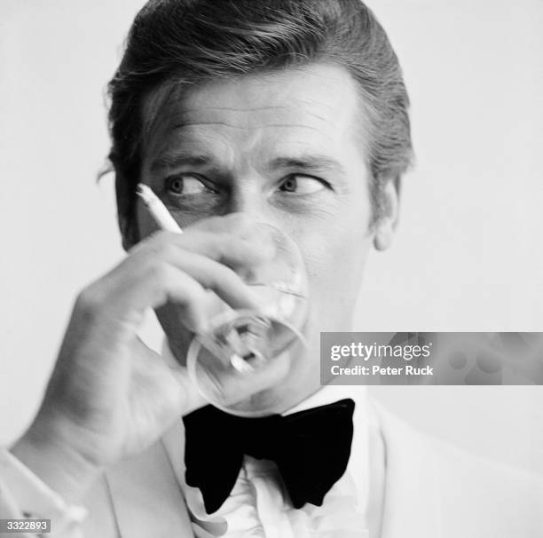 English actor Roger Moore, downs a Martini, 17th July 1968. Moore has recently been awarded his second Bravo Otto award for most popular television...