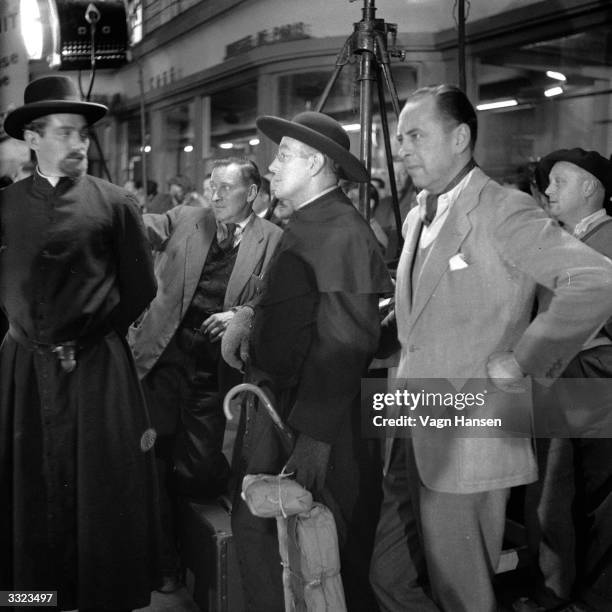 British actor Alec Guinness on location in Paris for the filming of 'Father Brown', in which he plays the famous priest detective created by G K...