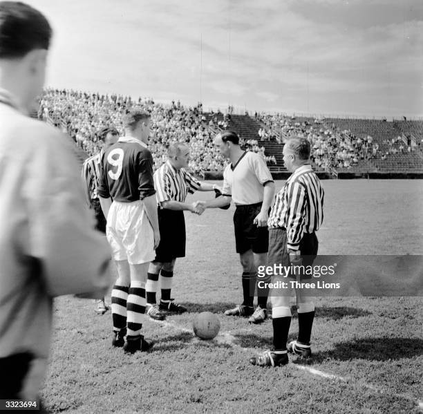 Officials and captains shake hands shortly before the kick off of a match between Chelsea and Borussia Dortmund football clubs in New York.