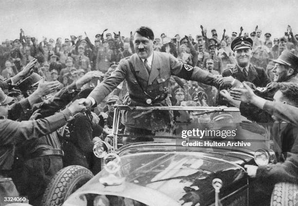 Adolf Hitler , chancellor of Germany, is welcomed by supporters at Nuremberg.