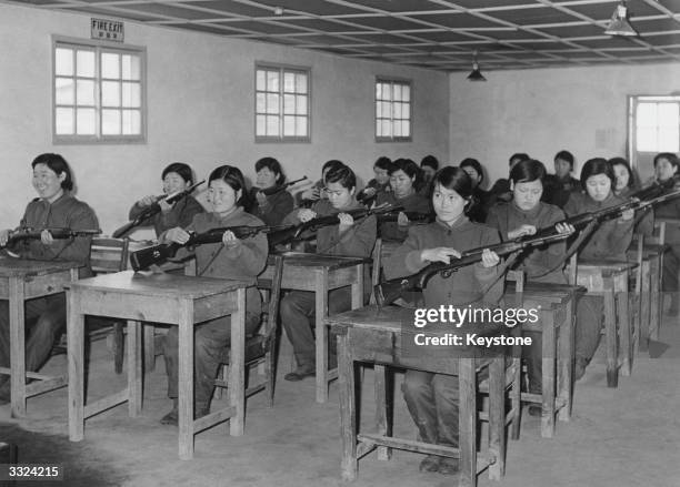 Women Auxiliaries of the Korean Army learn about their rifles during training near Seoul.