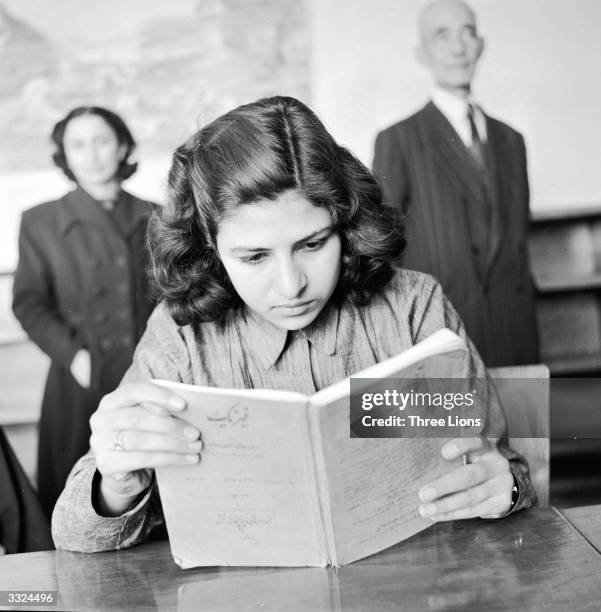 Girl student at a vocational training school for seamstresses studies the theoretical aspects of her work. This is one of the first schools for girls...