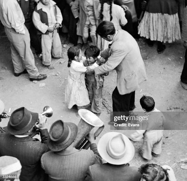 Children being taught the waltz whilst a brass band plays during Easter celebrations on Good Friday in Peru.