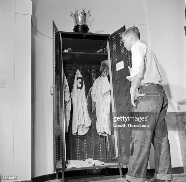 Visitor viewing the locker used by American baseball player Babe Ruth, topped with a silver crown trophy at Cooperstown Baseball Hall of Fame and...