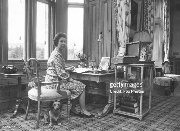 Queen Elizabeth II sitting in her study at Balmoral Castle, Scotland, dealing with despatch boxes containing State Papers sent from Whitehall.