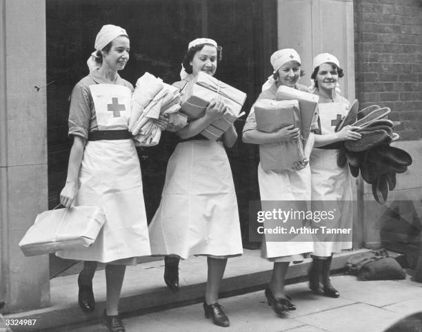 Four British Red Cross nurses carrying gift parcels from the USA and elsewhere which are to be distributed to patients in various hospitals