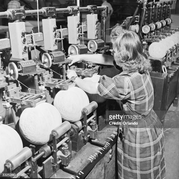 Worker making basket balls at the Spalding plant, Chicopee, Massachusetts. Automatic winders wrap the rubber bladder in a firm smooth case.