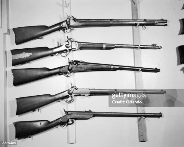 American Civil War Weapons; from top to bottom; a Confederate 58 calibre musket, a Sharps 52 calibre carbine single-shot equipped with target sights,...