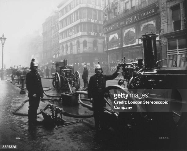 Firemen attending to a fire on Bread Street, London.