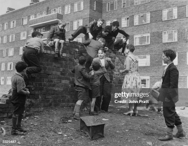 Stella Baker talking to boys beside blocks of housing in a deprived area of Liverpool. She encourages them to visit the Rodney Youth Centre, known as...