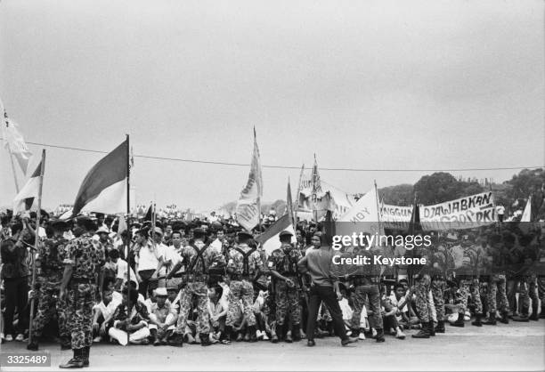 Indonesian troops bar a crowd of flag-waving students from the approach to president Achmed Sukarno's summer palace at Bogor in Indonesia following...