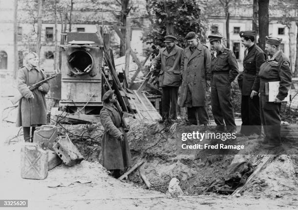 War correspondents are shown the grave where Adolf Hitler's charred body is alleged to have been buried, behind the Chancellery in Berlin.