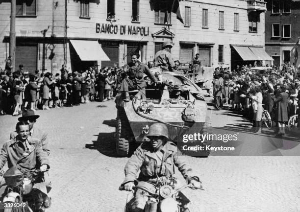 Crowds line the streets to greet US troops as they liberate Milan towards the end of the Second World War.