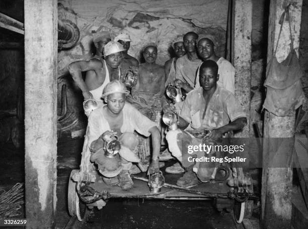 Group of miners with safety lamps in the Robinson Deep Gold Mine at Kimberley, South Africa.