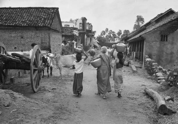 Three 'untouchables' carry water back to their huts in the village of Mudichur, 30 miles from Madras in south east India. Original Publication:...