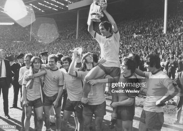 Arsenal captain Frank Mclintock holds aloft the FA Cup after his team's 2-1 victory over Liverpool.