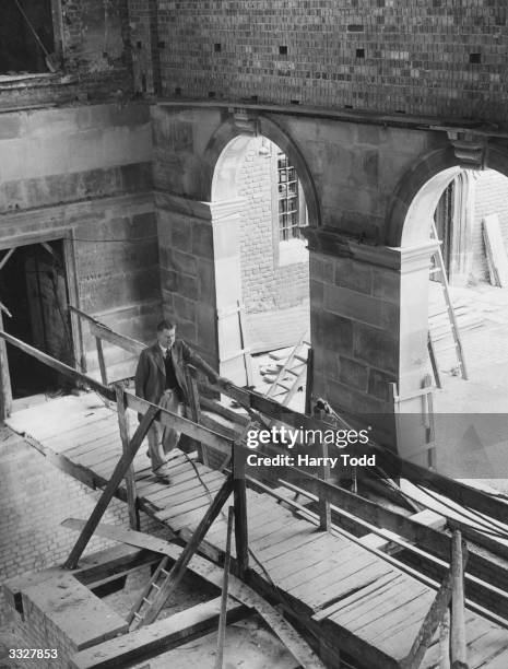 Wooden bridge spans the extensively bomb-damaged Upper School of Eton College, where restoration work is in progress. The roof, walls and floor were...