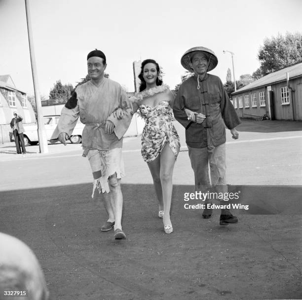 Comedian Bob Hope , actress Dorothy Lamour and film star and singer Bing Crosby walking arm-in-arm at Shepperton Studios during the filming of 'Road...