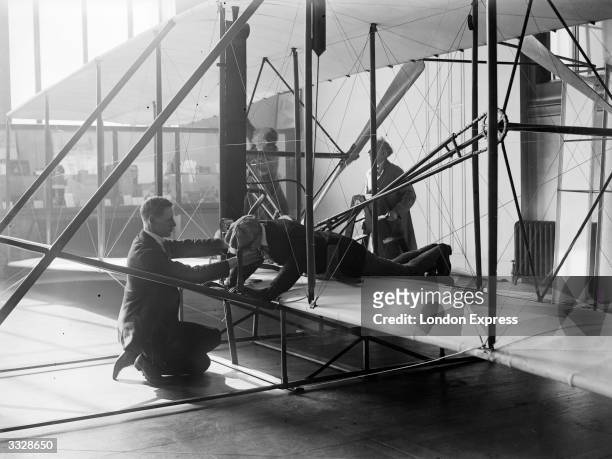 Dummy figure is fitted into the Wright brothers' biplane in preparation for exhibition at the Science Museum, in South Kensington, London. The...