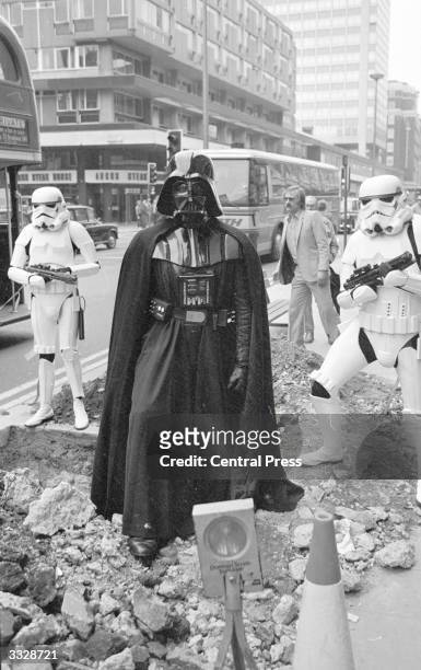 Darth Vader and two stormtroopers from the film 'Star Wars' stand menacingly over some road works in London's Oxford Street.
