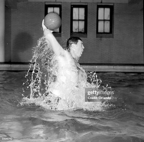 An American water polo player rises like a bullet out of the water to hurl the ball at the opposing goal.