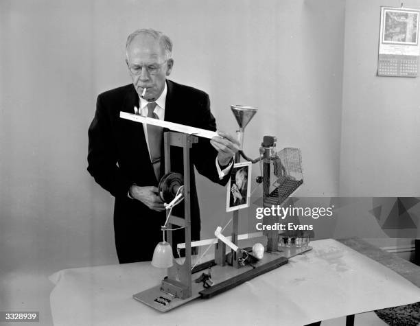 American amateur inventor Russell E Oakes demonstrates his complex cigarette lighter which is catalysed by a glass of water.