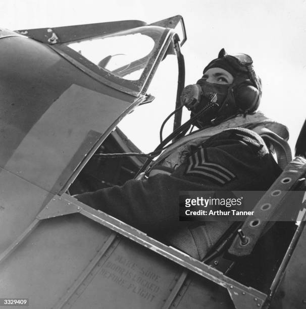 Fighter pilot sitting in the cockpit of his Spitfire after returning from a battle with enemy aircraft, July 1940.