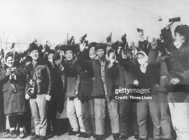Crowd of young Red Guards brandishing copies of their books of quotations from the writings of Chinese leader Mao Zedong . Their mood swings are...