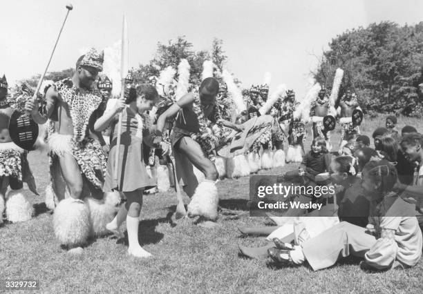 On Parliament Hill Fields members of a Zulu dance company in London to present 'Umabatha' based broadly on the story of Macbeth show a young school...