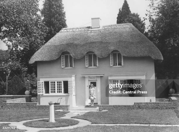 Princess Elizabeth at the doorway of the Welsh House, presented as a gift to her and Princess Margaret by the people of Wales, built in the grounds...