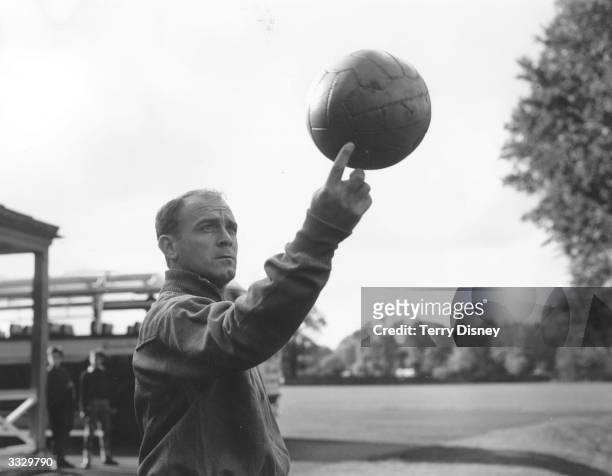 Spanish footballer Alfredo di Stefano, one of the world's greatest forwards, spinning a ball on one finger during Spain's team practice at Roehampton...