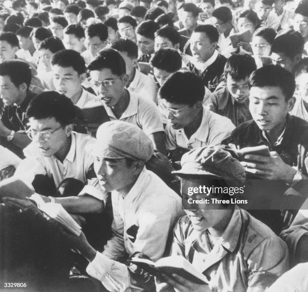 Crowd of young Red Guards reading from the writings of Chinese leader Mao Zedong and chanting in unison.