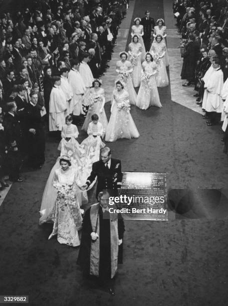 Princess Elizabeth and Prince Philip, Duke of Edinburgh in the aisle of Westminster Abbey, London, on their wedding day, followed by their...