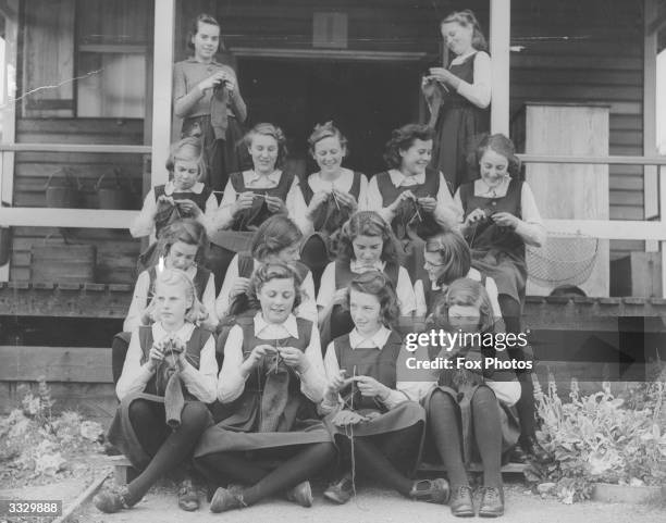 Girls from Beal County School, evacuated from Ilford to Finnamore Camp, Buckinghamshire, knit for troops in their spare time.