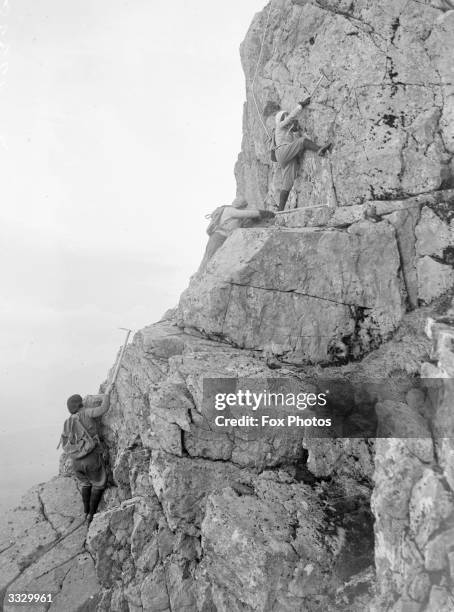 Two women climbers on a rock face on Ben Nevis, Scotland. Ben Nevis, in the Grampian Mountains near Fort William, is the tallest point in the British...