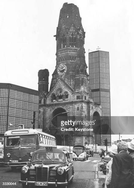 Taxi and bus ply their trade along the Kurfurstendamm in West Berlin, with the Gedachtniskirche in the background.